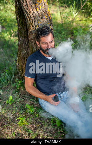 Sicher, man löst eine Wolke aus Dampf. Elektronische Zigarette Konzept. Stockfoto