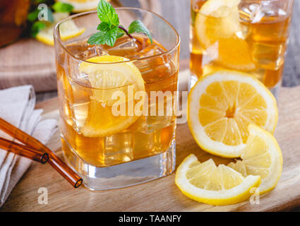 Nahaufnahme von einem Glas erfrischender Eistee mit Zitronenscheiben und Eiswürfel Stockfoto