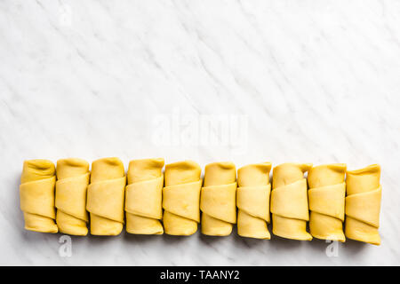 Mini Croissants in der Zeile auf Marmor tisch. Stockfoto