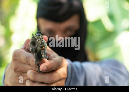 Wählen Sie Fokus der Waffe. Räuber in Schwarz ski Maske zielt mit der Waffe Stockfoto