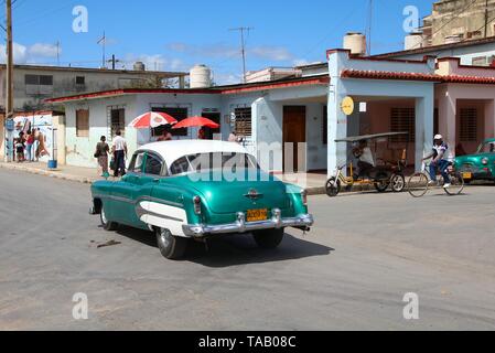 MORON, Kuba - 19. FEBRUAR 2011: Leute fahren ein altes Auto in Moron, Kuba. Kuba hat eine der niedrigsten Auto - Pro-Kopf-Rate (38 pro 1000 Personen im Jahr 2008). Stockfoto