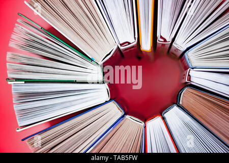 Herz aus Bücher auf rosa Hintergrund. Nähe zu sehen. Liebe Geschichte Konzept. Ansicht von oben Stockfoto