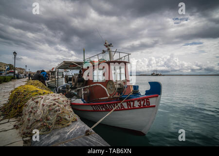 Zakynthos, Griechenland - April 2019: Große Haufen von Netzen und Fischer Boot am Ufer vertäut im Hafen von Zakynthos, Ionische Inseln Stockfoto