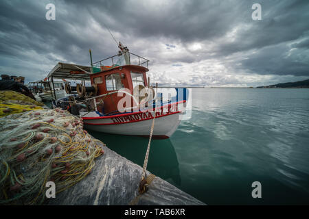 Zakynthos, Griechenland - April 2019: Große Haufen von Netzen und Fischer Boot am Ufer vertäut im Hafen von Zakynthos, Ionische Inseln Stockfoto