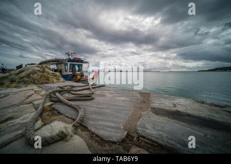 Zakynthos, Griechenland - April 2019: Große Haufen von Netzen und Fischer Boot am Ufer vertäut im Hafen von Zakynthos, Ionische Inseln Stockfoto