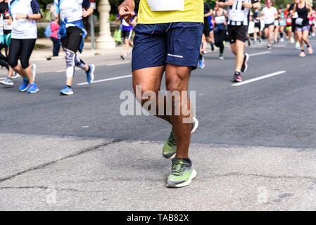 Muskulöse Beine eines männlichen Schwarzen Läufer konkurrieren in einem Amateur rennen durch die Straßen von Valencia, Spanien. Stockfoto