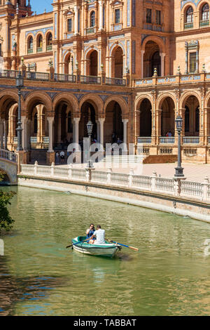 Paare, die in einem Ruderboot auf den See zum Bootfahren in der romantischen Umgebung der Plaza Espana, Sevilla, Region Andalusien, Spanien Stockfoto