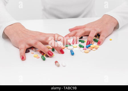 Schöne weibliche Hand hält Pille Geste. Stockfoto