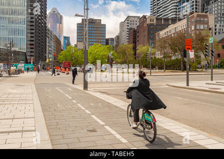 Montreal, Kanada - 21. Mai 2019: Eine Frau mit dem Fahrrad auf einem Radweg, der auf De Maisonneuve Boulevard. Stockfoto