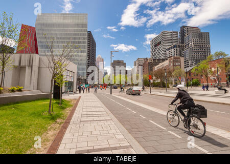 Montreal, Kanada - 21. Mai 2019: Eine Frau mit dem Fahrrad auf einem Radweg, der auf De Maisonneuve Boulevard. Stockfoto