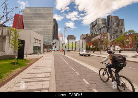 Montreal, Kanada - 21. Mai 2019: Ein Mann ist mit dem Fahrrad auf einem Radweg, der auf De Maisonneuve Boulevard. Stockfoto