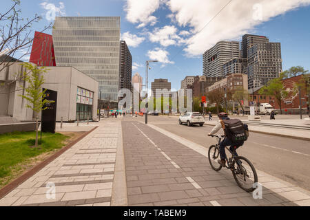 Montreal, Kanada - 21. Mai 2019: Ein Mann ist mit dem Fahrrad auf einem Radweg, der auf De Maisonneuve Boulevard. Stockfoto