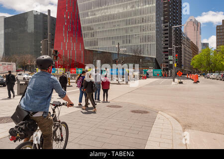 Montreal, Kanada - 21. Mai 2019: Ein Mann ist mit dem Fahrrad auf einem Radweg, der auf De Maisonneuve Boulevard. Stockfoto