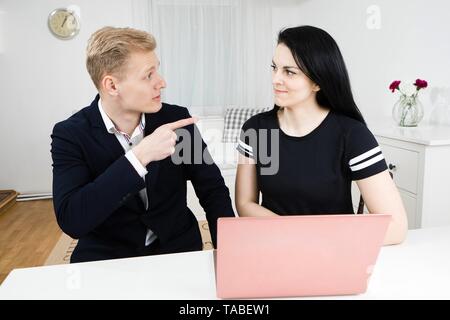 Vorgesetzten arbeitet mit untergeordneten, blonder Mann mit schwarzen behaarte Frau, emotional diskutieren Stockfoto