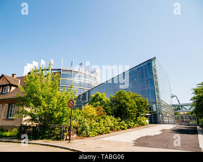 Ruhigen friedlichen Blick auf die hintere Fassade des Europäischen Parlaments Blick durch treees und Häuser-Zentrale in Straßburg einen Tag vor 2019 zu den Wahlen zum Europäischen Parlament - Strahlend blauer Himmel. Stockfoto