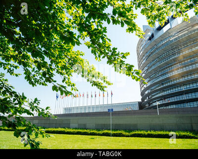 Ruhige friedliche Aussicht der breiten Fassade des Europäischen Parlaments Blick durch die Bäume der Zentrale in Straßburg einen Tag vor 2019 zu den Wahlen zum Europäischen Parlament - clear blue sky Stockfoto