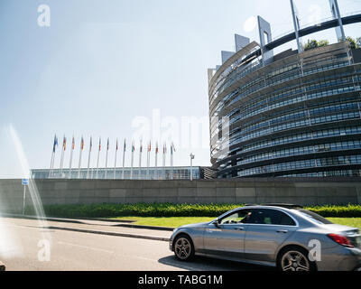 Straßburg, Frankreich, 23. Mai 2019: Mercedes Benz E klass Silver Executive Auto am Hauptsitz des Europäischen Parlaments Gebäude im Hintergrund alle EU-Mitgliedstaaten Fahnen schwenkten Stockfoto