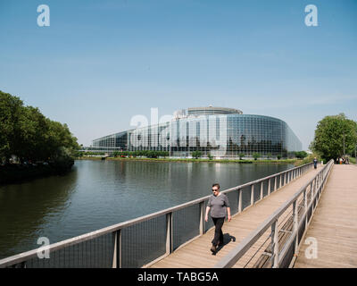 Straßburg, Frankreich, 23. Mai 2019: erwachsene Frau zu Fuß auf die Brücke mit dem Europäischen Parlament zentrale Gebäude im Hintergrund Stockfoto