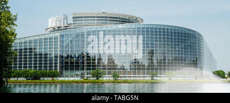 Breite Fassade Hauptsitz des Europäischen Parlaments in Straßburg einen Tag vor 2019 zu den Wahlen zum Europäischen Parlament - klaren blauen Himmel und ruhige Ill Wasser in der Glasfassade wider. Stockfoto