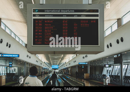 Man reisenden Fluggast schaut Flugplan Timetable board Bildschirm am Terminal, O.P. Tambo International Airport, Johannesburg, Südafrika Stockfoto