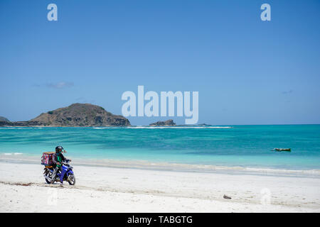 Eis Verkäufer auf dem Fahrrad auf dem weißen Sandstrand von Pantai Tanjung Aan Beach in Kuta, Lombok, Indonesien, 09.08.2018 Stockfoto