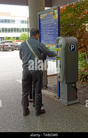 Man kauft ein Ticket von einer automatisierten kostenpflichtige Parkplätze Maschine Richmond am allgemeinen Krankenhaus, Richmond, BC, Kanada Stockfoto
