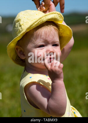 Baby Mädchen in einem gelben Kleid. Stockfoto