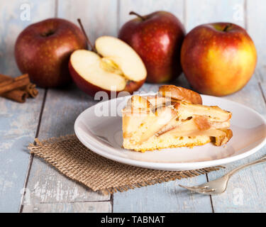 Apfelkuchen mit Äpfeln und einem hölzernen Hintergrund Stockfoto