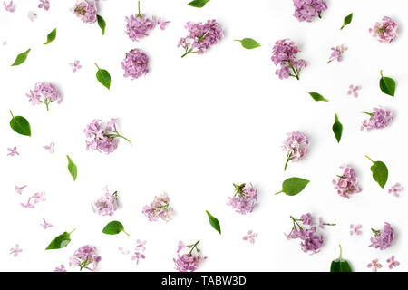 Rahmen mit Blättern und lila Blüten auf weißem Hintergrund. Flach, Ansicht von oben Stockfoto
