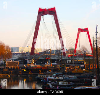 Willemsbrug, die rote Brücke in Rotterdam bei Sonnenuntergang über dem Hafen gesehen Stockfoto