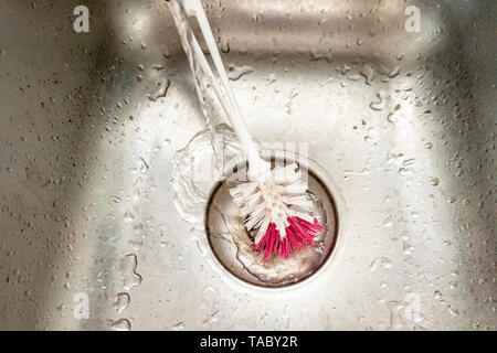 Wasser in der Spüle mit Pinsel reinigen Stockfoto