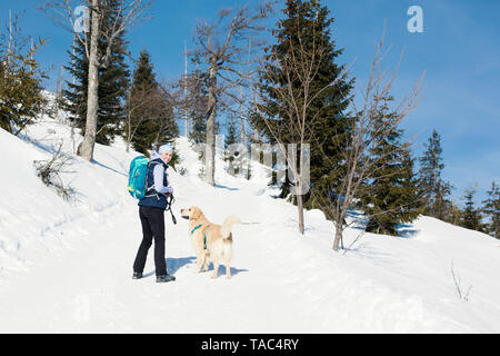 Deutschland, Bayerischer Wald, Lusen, lächelnde Frau mit Hund wandern im Winter Stockfoto