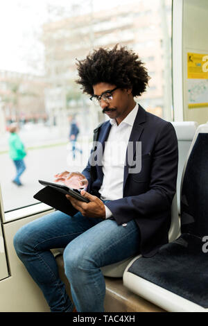 Spanien, Barcelona, Geschäftsmann, der in einer Tablette Straßenbahn Stockfoto