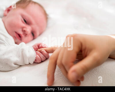 Neugeborene Mädchen, dass Mütter Finger Stockfoto