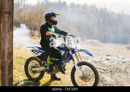 Motocross Fahrer auf Motorrad mit Rauch aus der Auspuffleitung Stockfoto