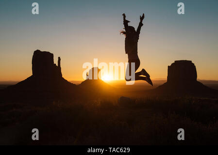 USA, Utah, Monument Valley, Silhouette, die glückliche Frau, springen in die Luft, bei Sonnenaufgang Stockfoto