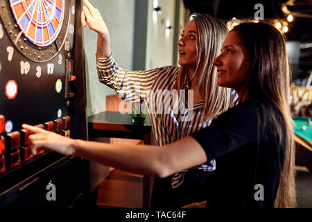 Zwei Frauen spielen Dart elektronische Dartscheibe einstellen Stockfoto