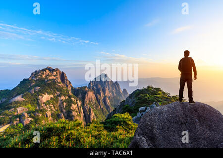 Junge glücklich Backpacker auf einem Berg mit Blick auf das Tal Stockfoto