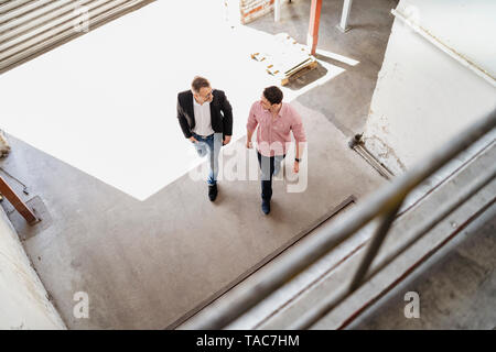 Aus der Vogelperspektive zwei Männer gehen mit Laderampe in einer Fabrik Stockfoto