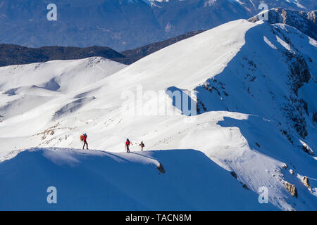 3 Bergsteiger gehen auf Schnee in den Bergen Stockfoto