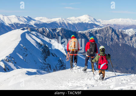 3 Bergsteiger gehen auf Schnee in den Bergen Stockfoto