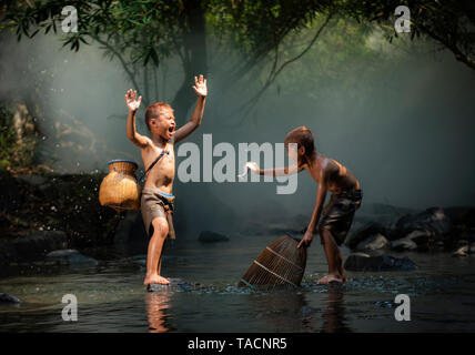 Asien Kind Leben lachen Fischer auf dem Fluss stream/Der junge Freund gerne lustig Lachen und Lächeln boy Angeln Fischen in der Hand an Landschaft leben Stockfoto