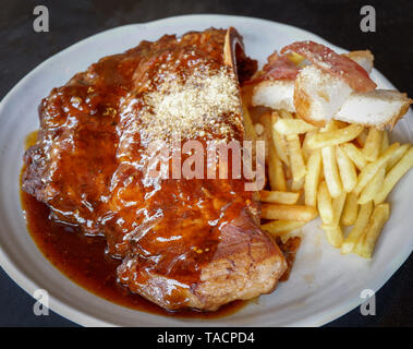 Pork Rib Steak servieren auf Platte/Grill Schweinebraten Pommes frites Speck und pikanter Sauce - Grill Spare Ribs honey Dip Stockfoto