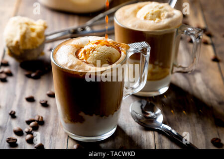 Gießen Kaffee auf Vanilleeis ein affogato Kaffee auf einem rustikalen Holztisch zu machen Stockfoto