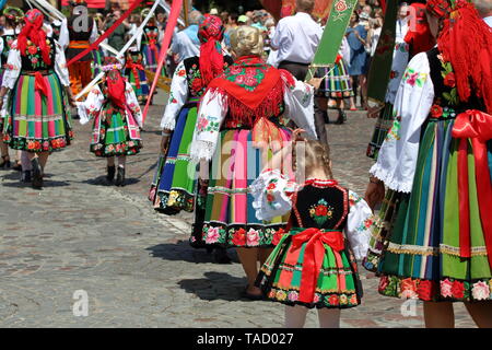 Einheimische aus Lowicz in Polen in traditionellen bunten Trachten gehen in annyal Fronleichnam Prozession in der Stadt Straße. Stockfoto