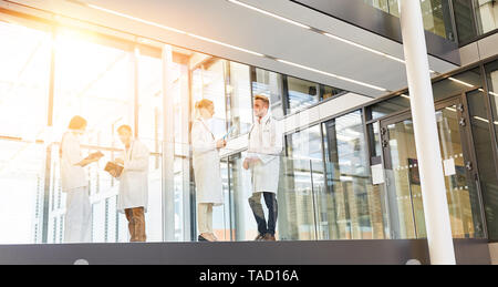 Modernes Krankenhaus mit Ärzten und Krankenschwestern in den Flur, während im Gespräch Stockfoto