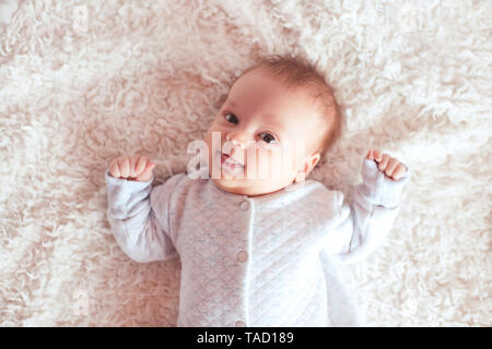 Lustige Baby im Bett lag, an der Kamera schaut. Kindheit. Guten Morgen. Stockfoto