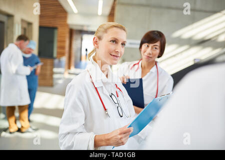 Junge Ärztin besprechen, eine Therapie mit einem Kollegen für einen Patienten Stockfoto