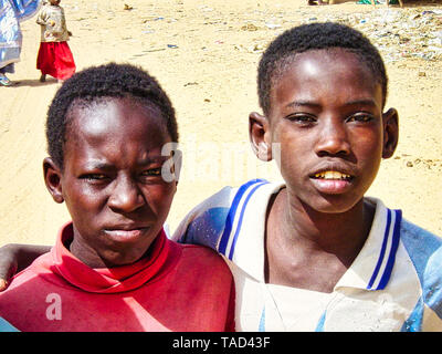 TIMBUKTU, MALI - Februar circa, 2019. Nicht identifizierte zwei Kind jugendlich Jungen in der Wüste stehen mit frindship, in die Kamera schaut. Sehr armen ländlichen Kid. Stockfoto