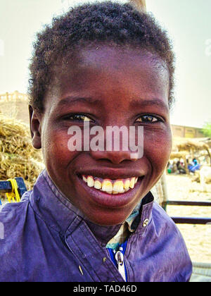 TIMBUKTU, MALI - Februar circa, 2019. Nicht identifizierte Malischen Junge lächelt und stellt in der Straße in Timbuktu. Kinder in Afrika leiden der Armut aufgrund Stockfoto